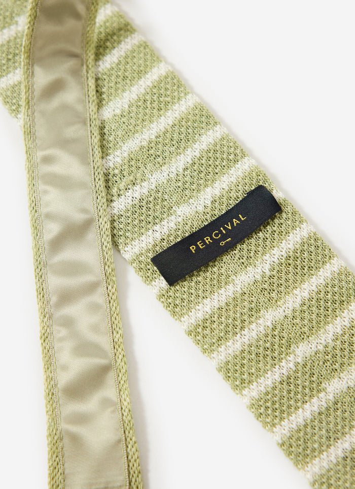 Close up of the Percival Stripe Linen Tie in Sage Marl, showing the green and ecru striped knitted texture and brand label.