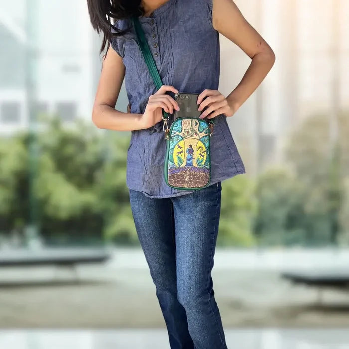 A woman modeling the Strong Earth Woman Phone Bag designed by Métis artist Leah Dorion, showcasing its unique design.