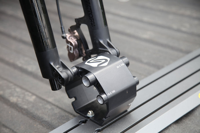 Saris Traps thru-axle fork mount — mountain bike secured in truck bed, trail access