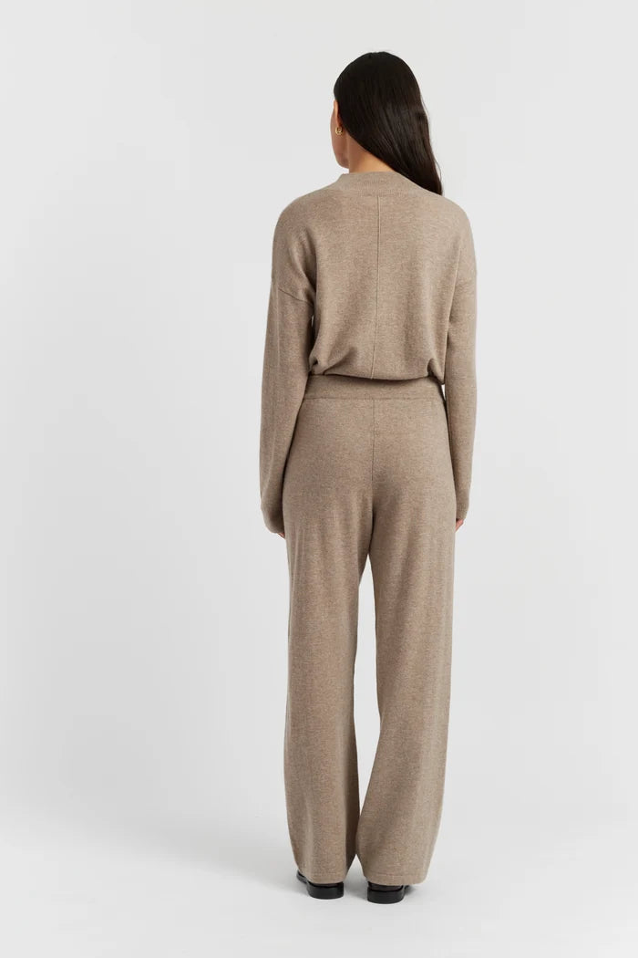 Woman wearing a beige knit suit on a white background