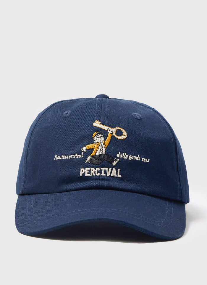 A studio shot of the Percival World Key Cap in navy, showing the detailed embroidery of a man holding a large key.